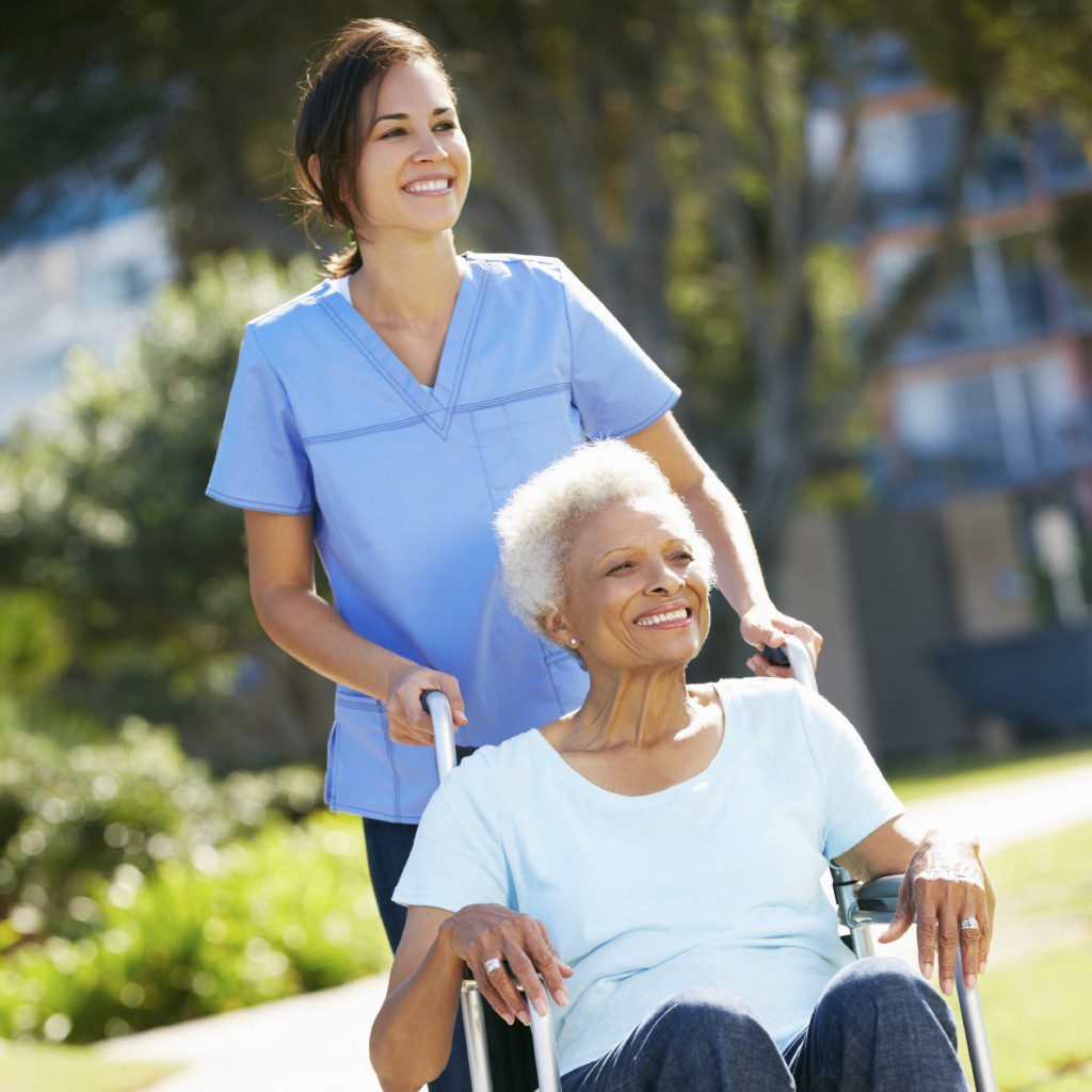 Carer Pushing Senior Woman In Wheelchair - Cahoon Care Associates Carer Pushing Senior Woman In Wheelchair