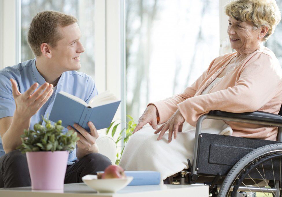 Caregiver reading to senior woman at home - Cahoon Care Associates Caregiver reading to senior woman at home